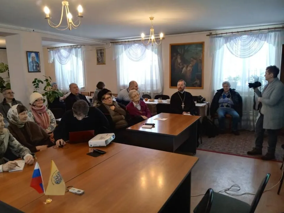 Участники историко-краеведческой конференции сидят за столами в помещении собора