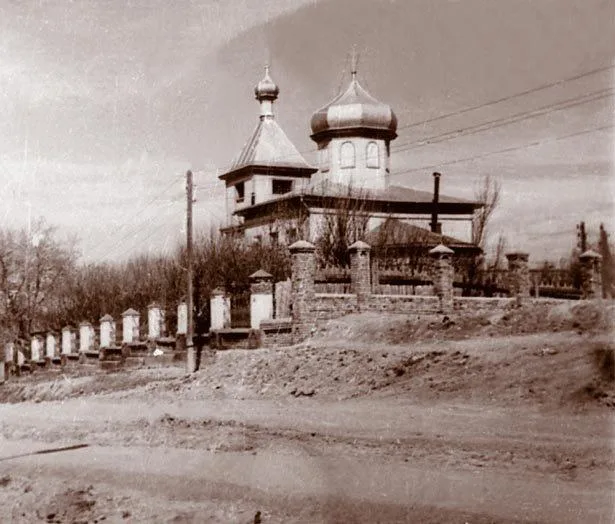 Старая фотография деревянной церкви, вид с улицы с телеграфными столбами