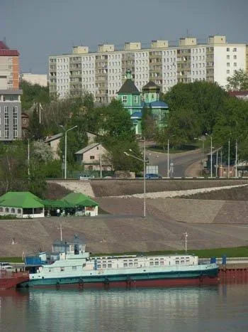 Панорама с рекой и теплоходом на переднем плане, храм и новые многоэтажки на склоне холма